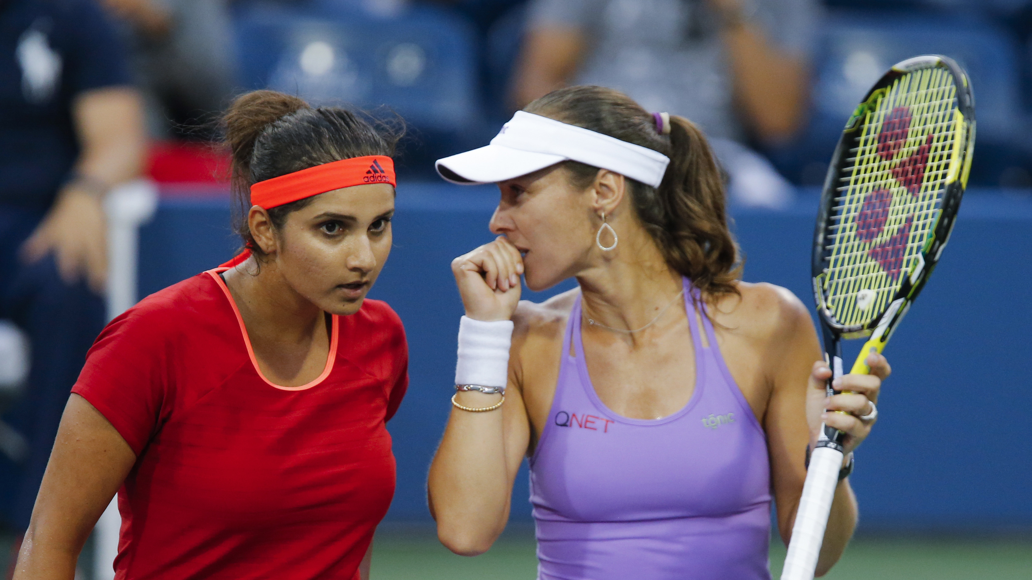 Sania Mirza of India (L) confers with playing partner Martina Hingis of Switzerland during their women's doubles semifinals match against Sara Errani and Flavia Pennetta, both of Italy, at the U.S. Open Championships tennis tournament in New York, September 9, 2015. REUTERS/Eduardo Munoz - RTSED6