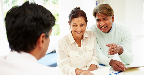 Senior Indian Couple Meeting With Financial Advisor At Home