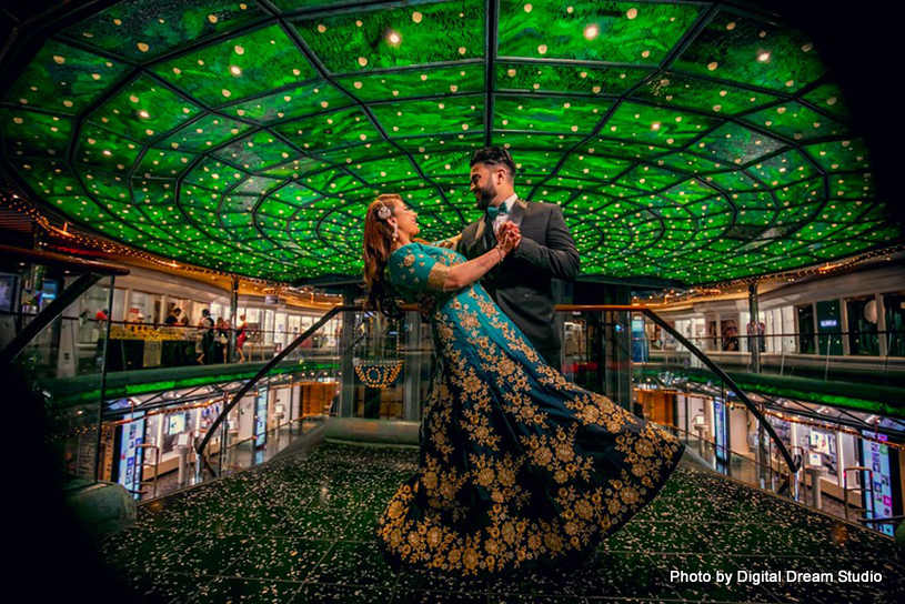 Indian bride and groom posing under incredible venue decor