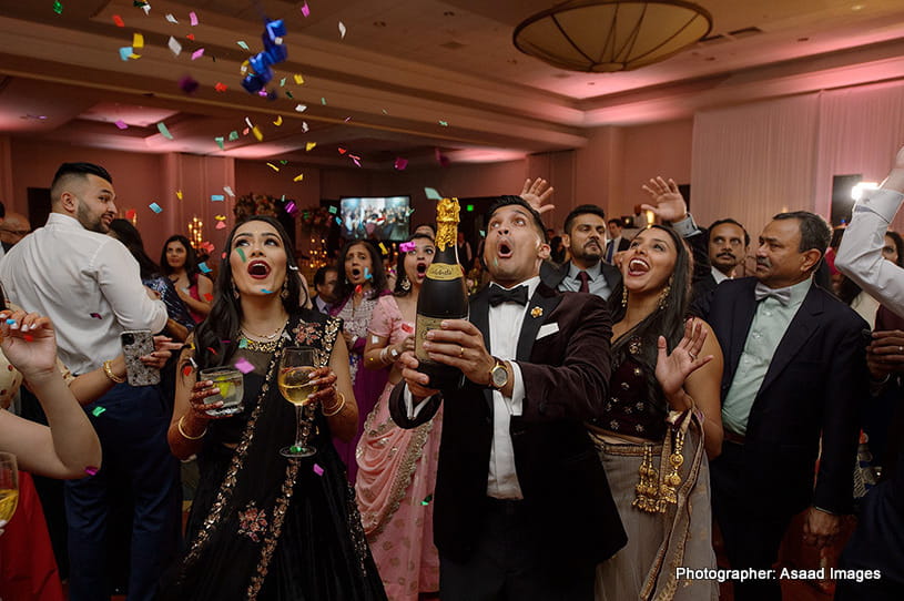 Indian Groom opening champagne bottle