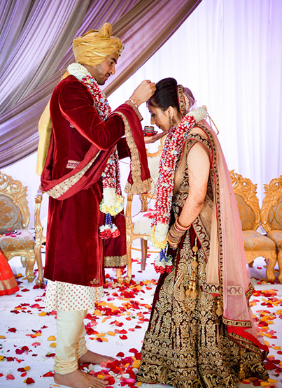 Groom applying sindoor to the bride