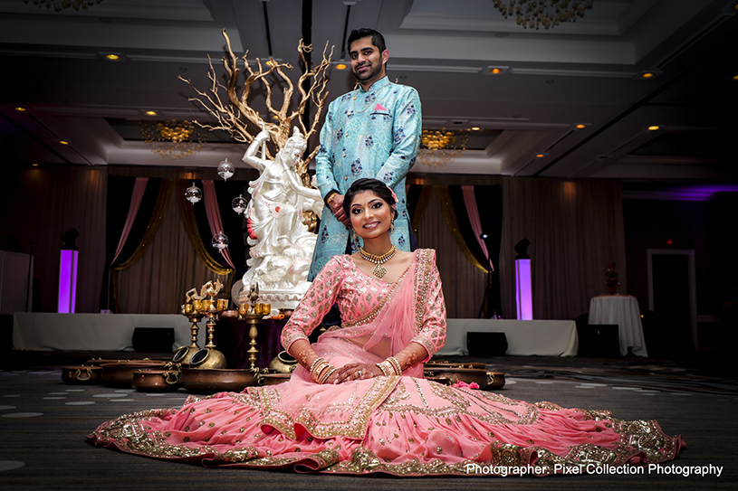 Indian bride and groom posing with their sangeet outfits