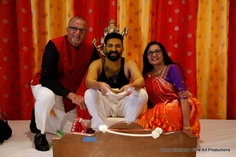 Indian wedding ritual of painting the groom with yellow turmeric paste