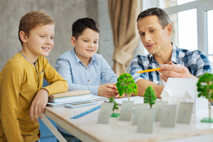 Young engineer discussing his eco-city project with sons