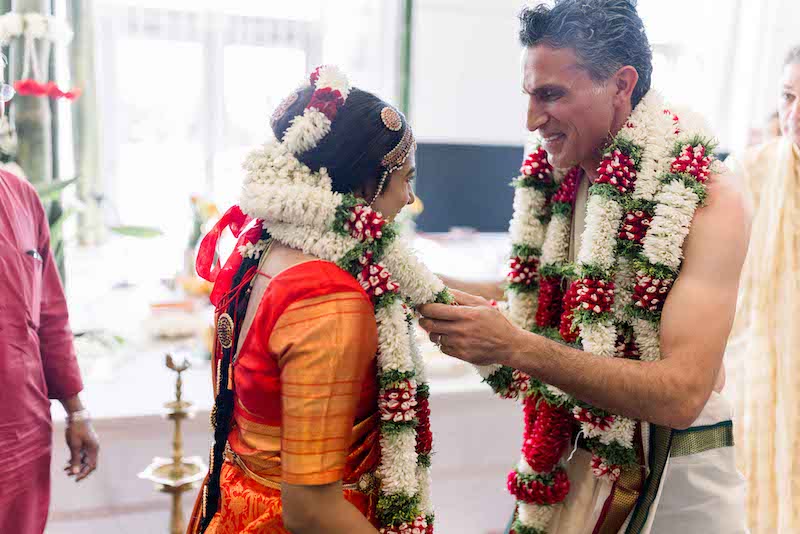 Indian groom wears garland to bride