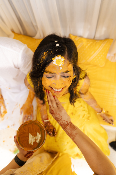 Wedding guest applying Haldi on bride's face