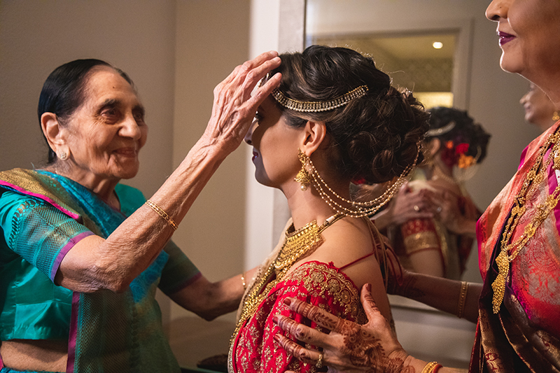 Indian Bride's Grand Mother helping bride to get ready