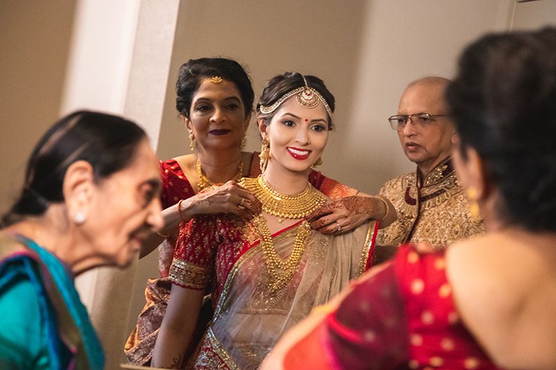 Parents helping bride getting ready for her wedding