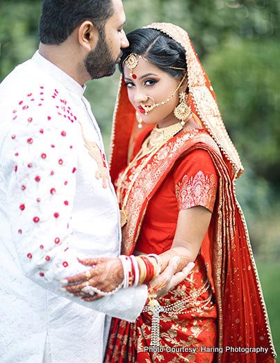 Groom kissing bride on forehead