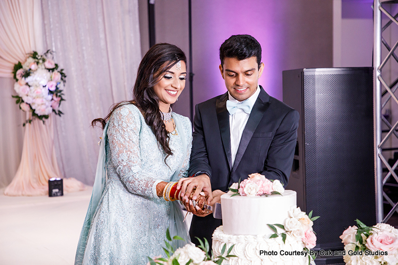 Indian wedding couple cutting indian wedding cake