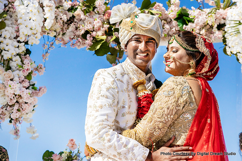 Indian wedding couple under wedding mandap