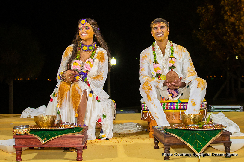 Applying turmaric on bride and groom's face by their guest