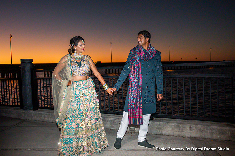 Indian bride and groom walking with holding each others hands