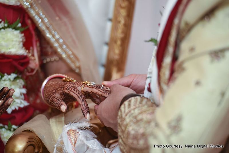 Groom going to put ring on Bride's Finger