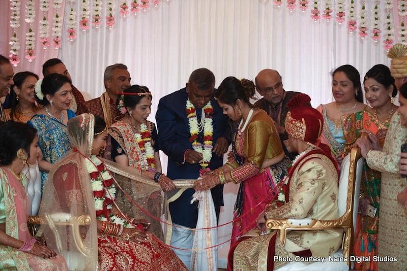 Indian couple doing ritual wih their family