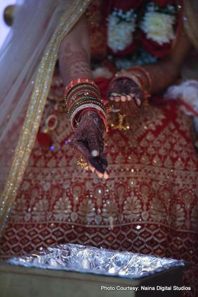 Indian bride putting something in holy fire