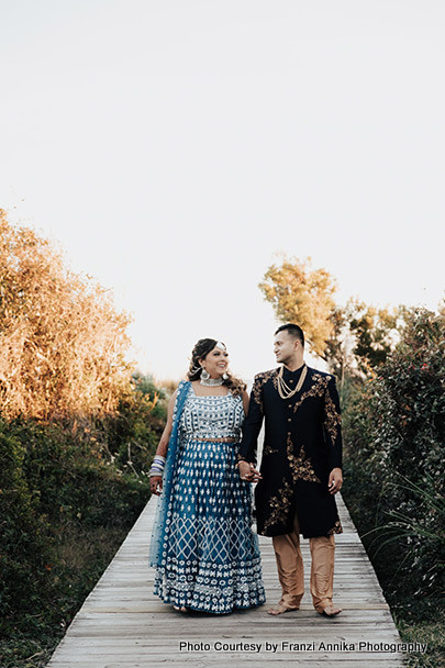 Indian bride and groom walking with holding hands