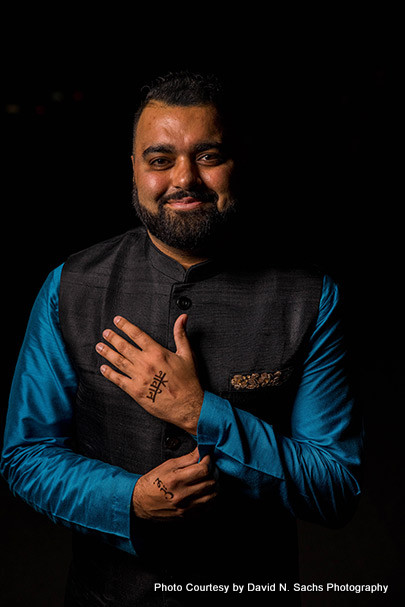 Indian groom putting tattoo of his love's name