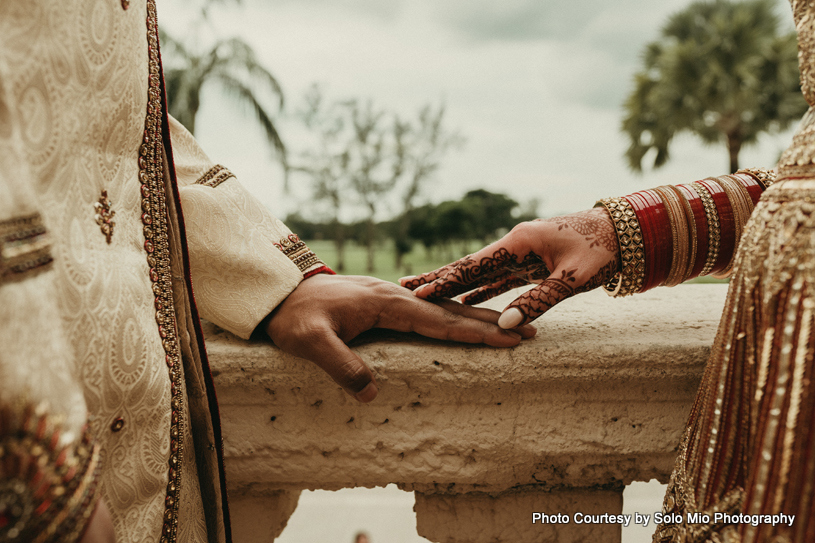 Indian bride and groom holding their hands