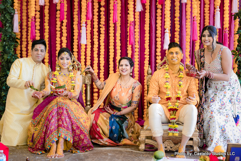 Indian wedding guest applying haldi on bride and groom's face 