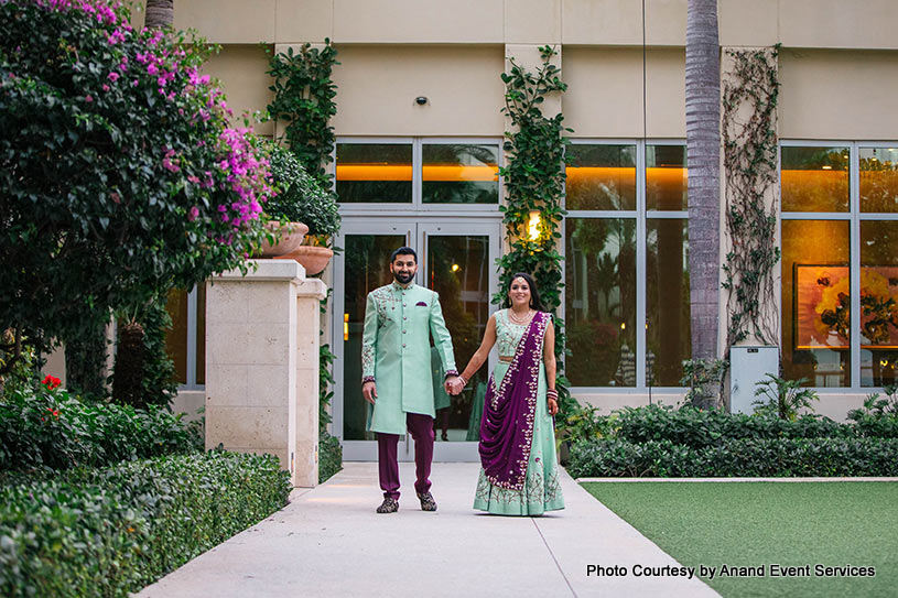 Indian bride and groom walking with holding eachother's hand
