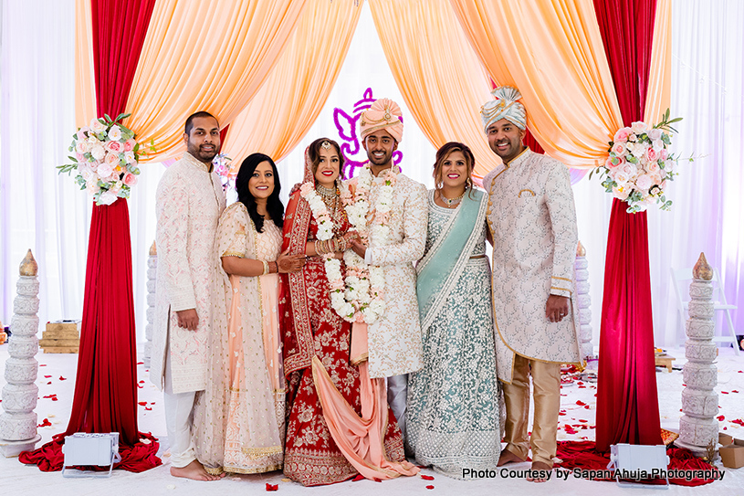 bride and groom with family under mandap capture