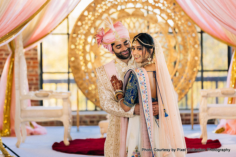 Indian groom holding in arms Indian bride tightly