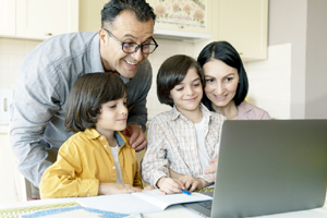 family looking together laptop