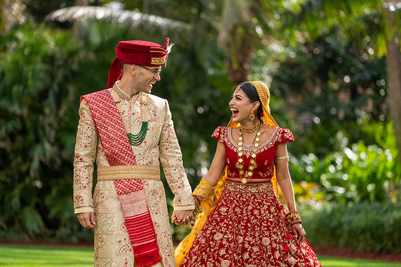 Indian bride and groom holding hands each other