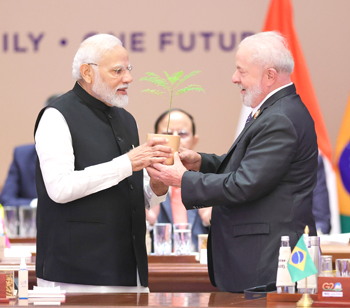 India s Prime Minister Narendra Modi presents a sapling to Brazil s President Luiz Inacio Lula