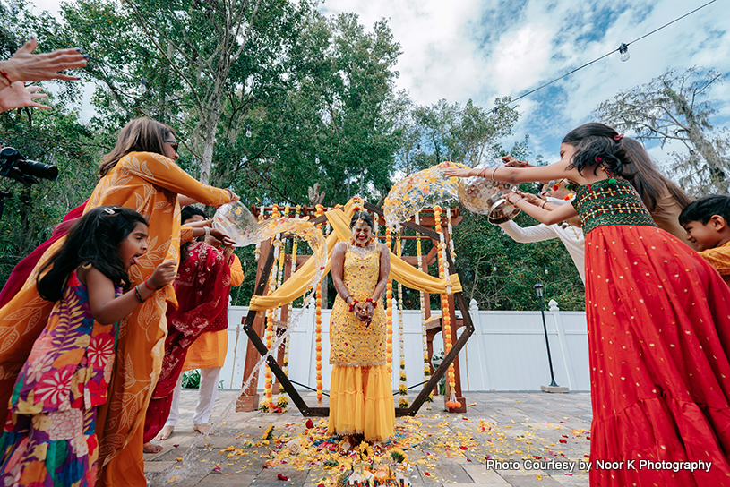 indian bride and her cousin playing with water