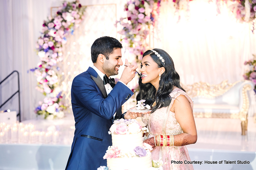 Indian wedding couple feeding cake each other