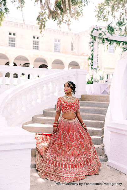 Kashmira in her bridal lehenga, adorned with intricate jewelry and henna, smiling gracefully.