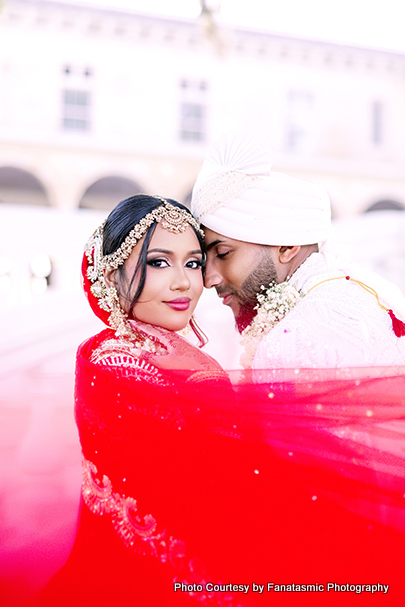 Newlyweds Kashmira and Paul walking hand in hand outdoors in wedding attire