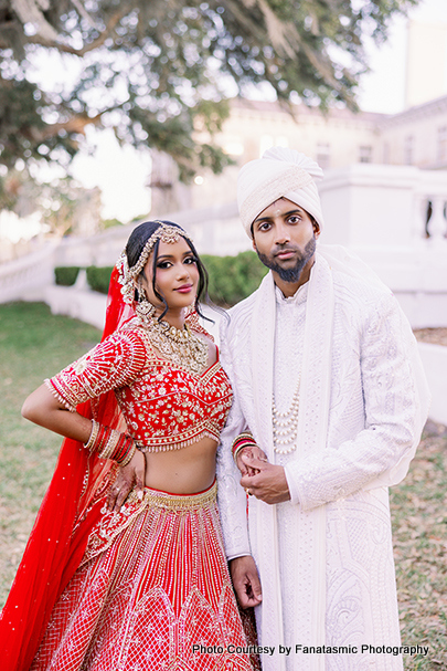 Kashmira and Paul in traditional wedding attire embracing each other