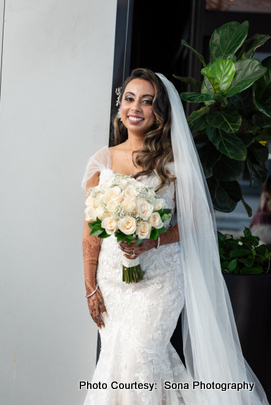 Ami posing for a photograph in her bridal outfit