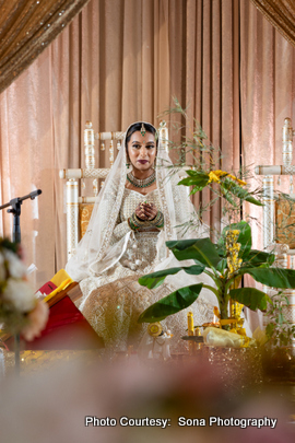 A portrait of the bride dressed in traditional attire with a long veil, radiating grace and joy.