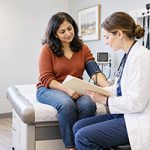 Indian American woman discussing her health with a doctor during a medical checkup