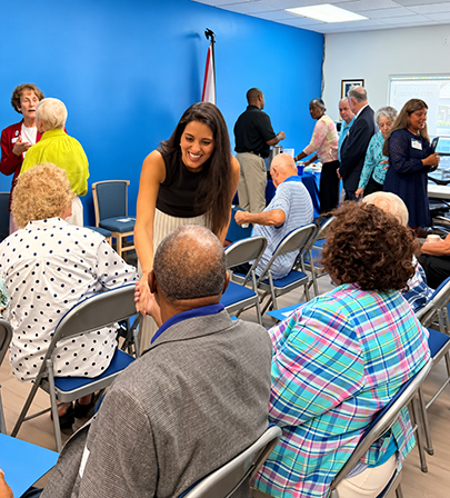 Woman speaking with community members at a public event Experience in Washington and the Private Sector