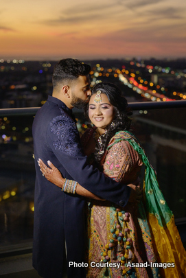 Tithi and Bhaumik embracing with city lights backdrop during nighttime wedding photoshoot