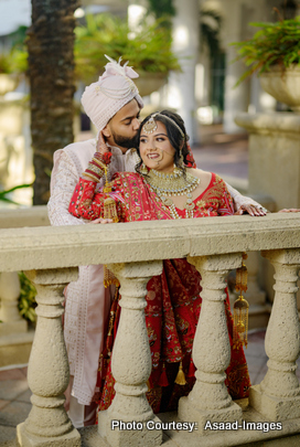 Tithi and Bhaumik posing together in traditional red Indian wedding attire