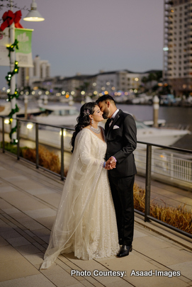 Tithi and Bhaumik posing together near waterfront during evening wedding photoshoot in Tampa