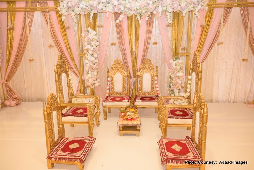 Elegant pastel-themed Indian wedding mandap with floral decor and traditional ceremonial chairs