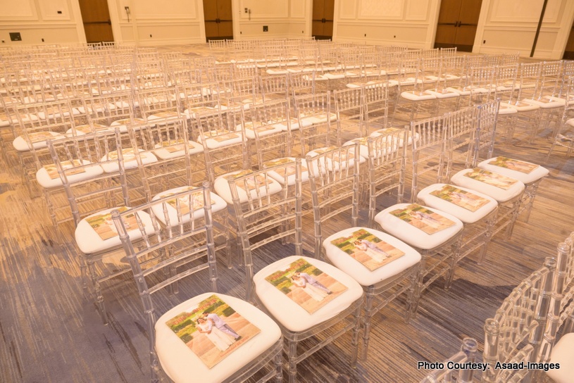 Indian wedding ceremony seating arrangement with transparent chairs and printed programs at Tampa wedding venue