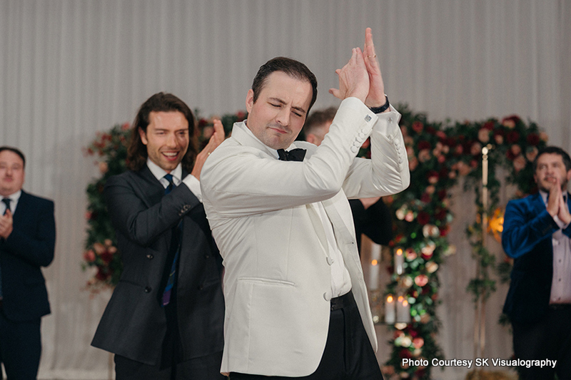 Groom Mark dancing joyfully with friends during wedding reception party